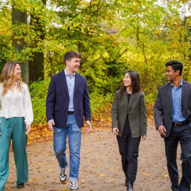 Wir Studierende, zwei Männer, zwei Frauen, laufen durch den Wald.