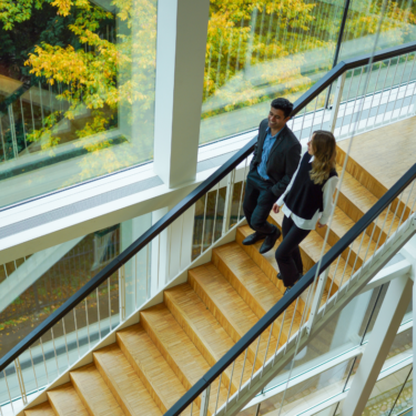 Zwei Studierende gehen eine Treppe hinunter.