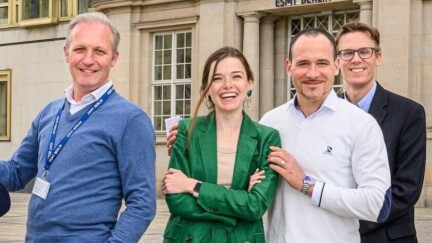 4 Personen stehen lächelnd vor der ESMT