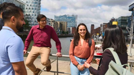 Studierende der KLU stehen in der Hamburger HafenCity. Im Hintergrund die Elbphilharmonie