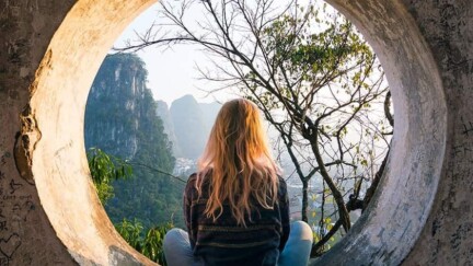 Frau sitzt in rundem Beton